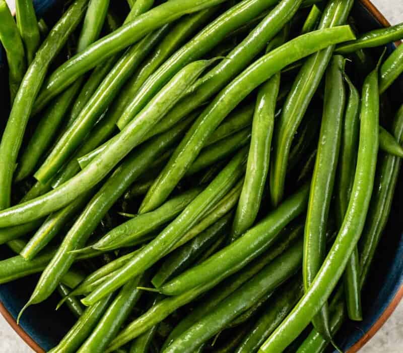 blanched green beans in a blue bowl