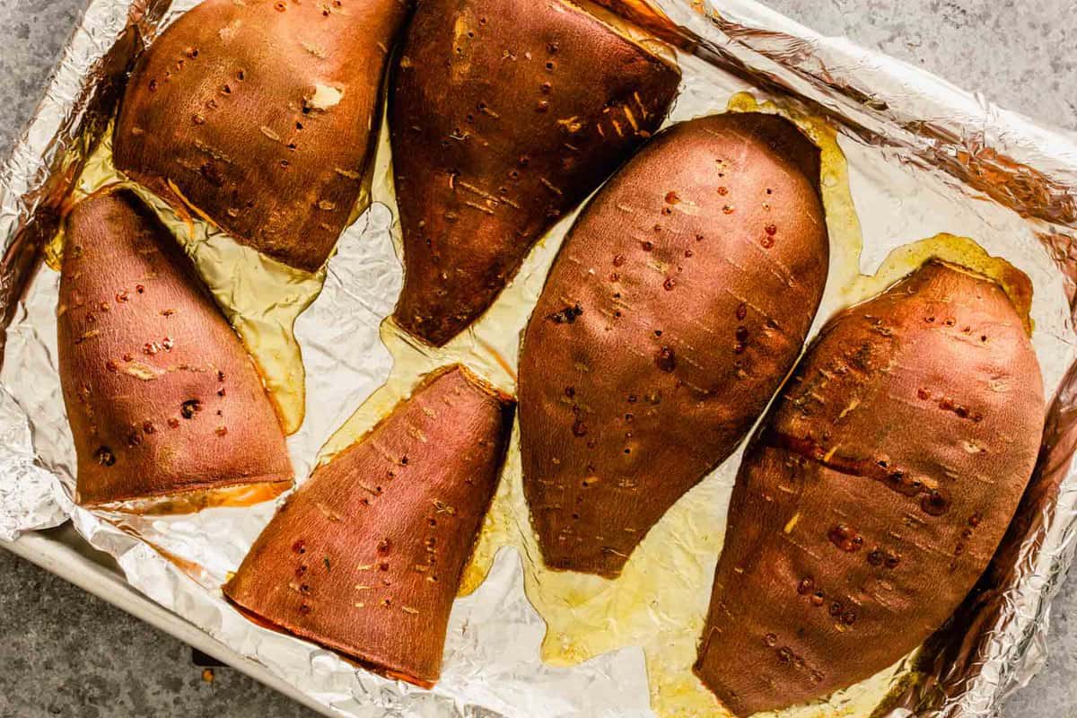 roasted sweet potato halves on a foil-lined baking sheet