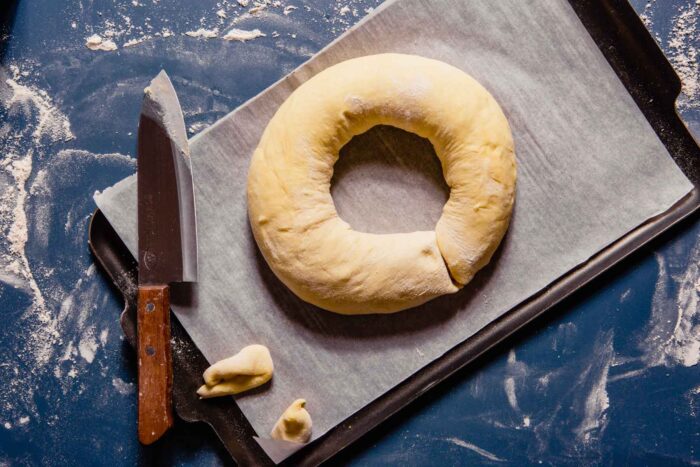 dough log formed into a ring on a baking sheet