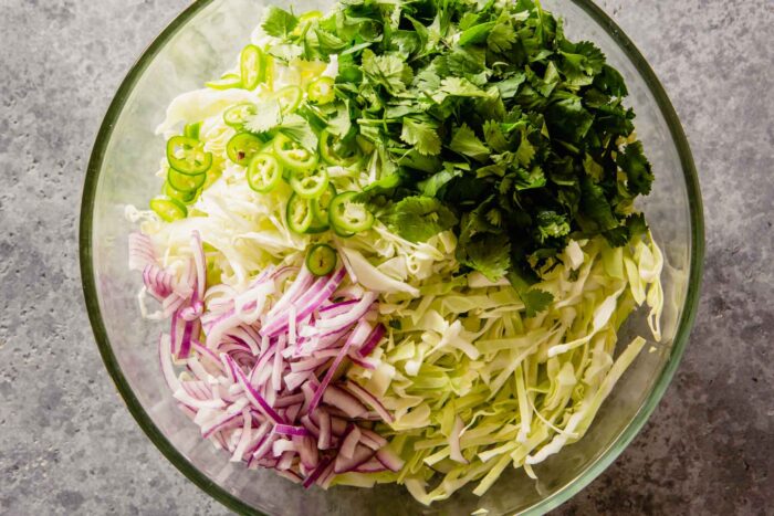 cabbage, red onion, cilantro, and serrano in a large bowl.