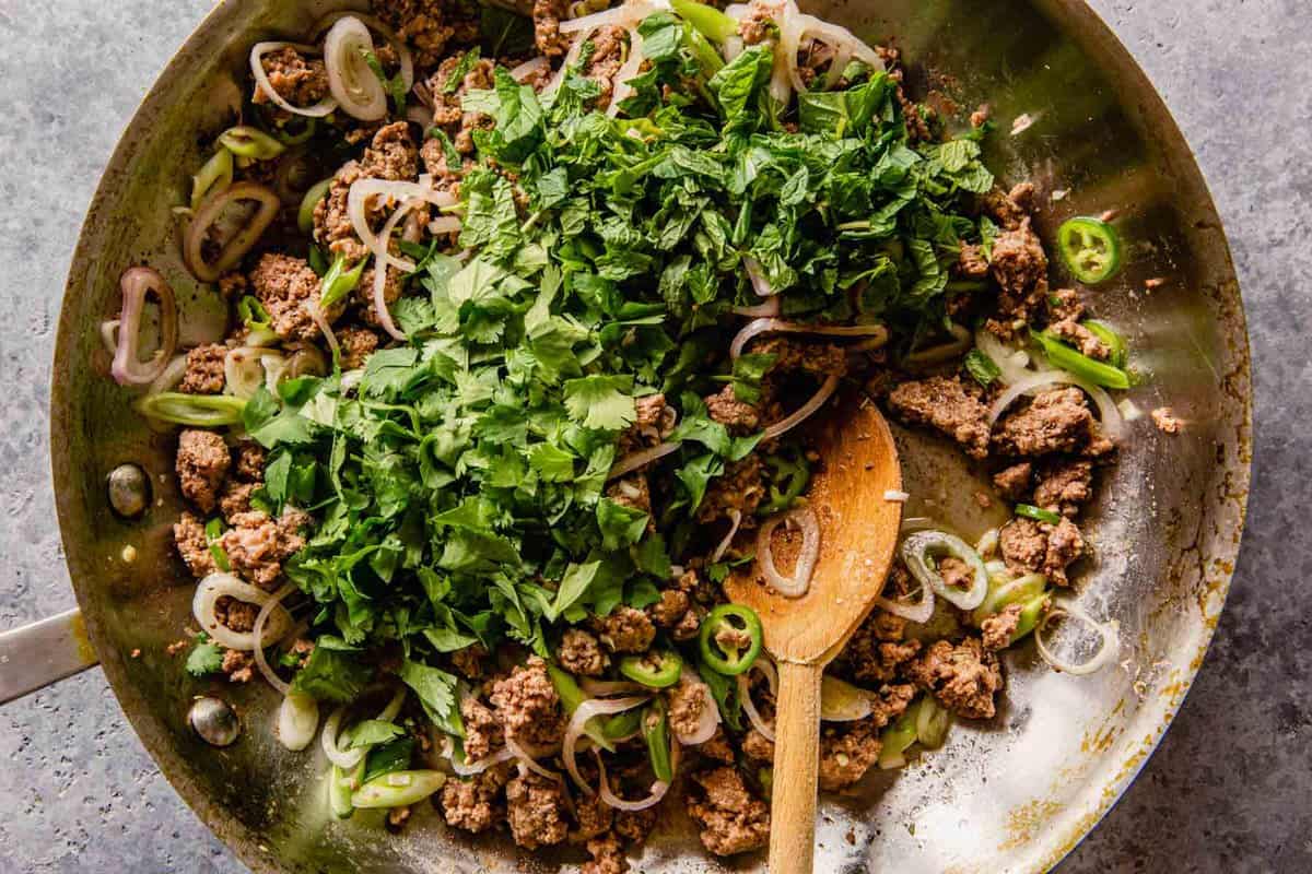 ground beef, herbs and shallots in a skillet
