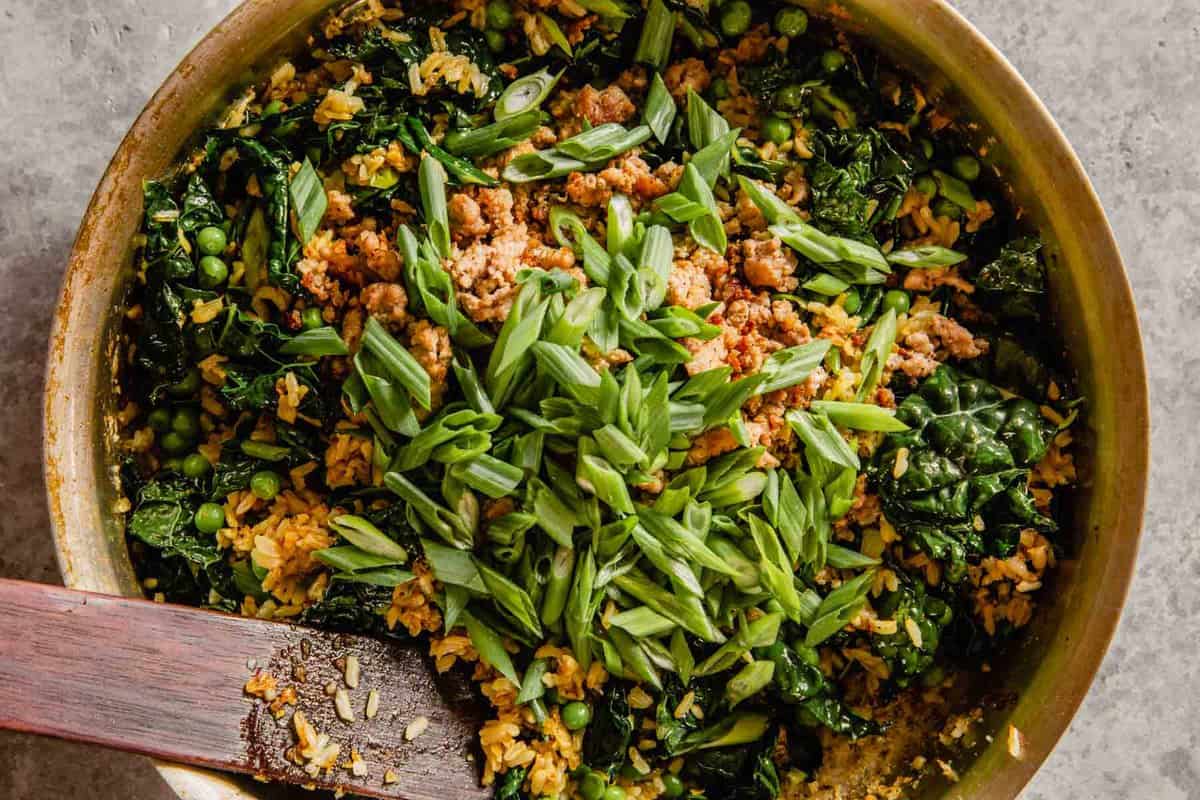 kale, scallions, and pork in a skillet