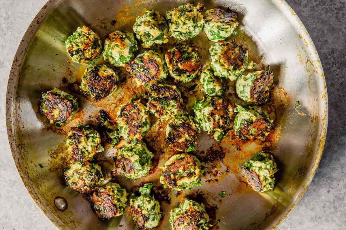 chicken and spinach meatballs cooking a sauté pan