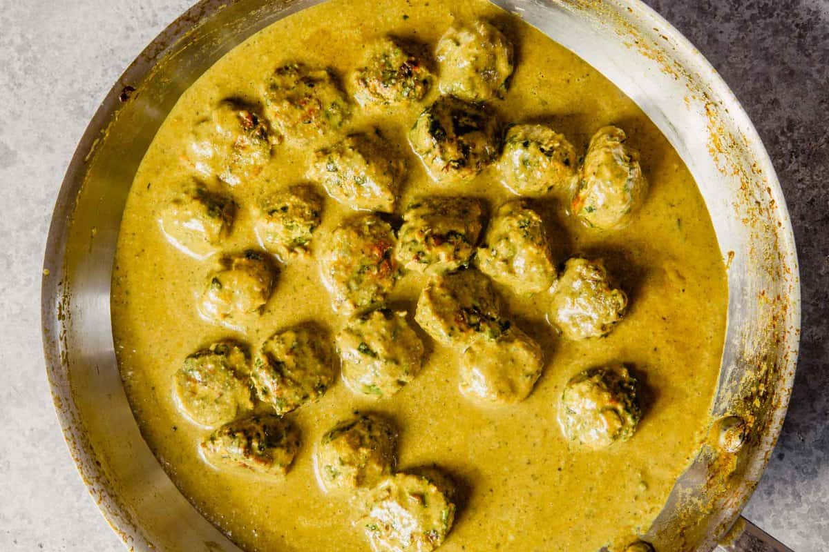 meatballs in a curry sauce in a sauté pan