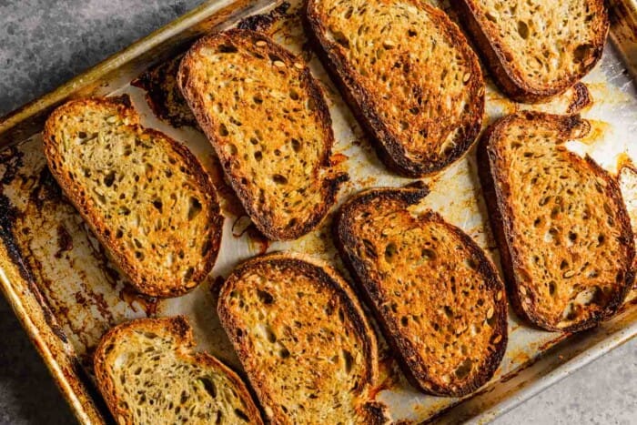 slices of toasted whole wheat bread on a baking sheet