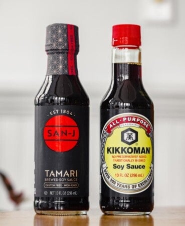 a bottle of soy sauce and a bottle of tamari set on a table