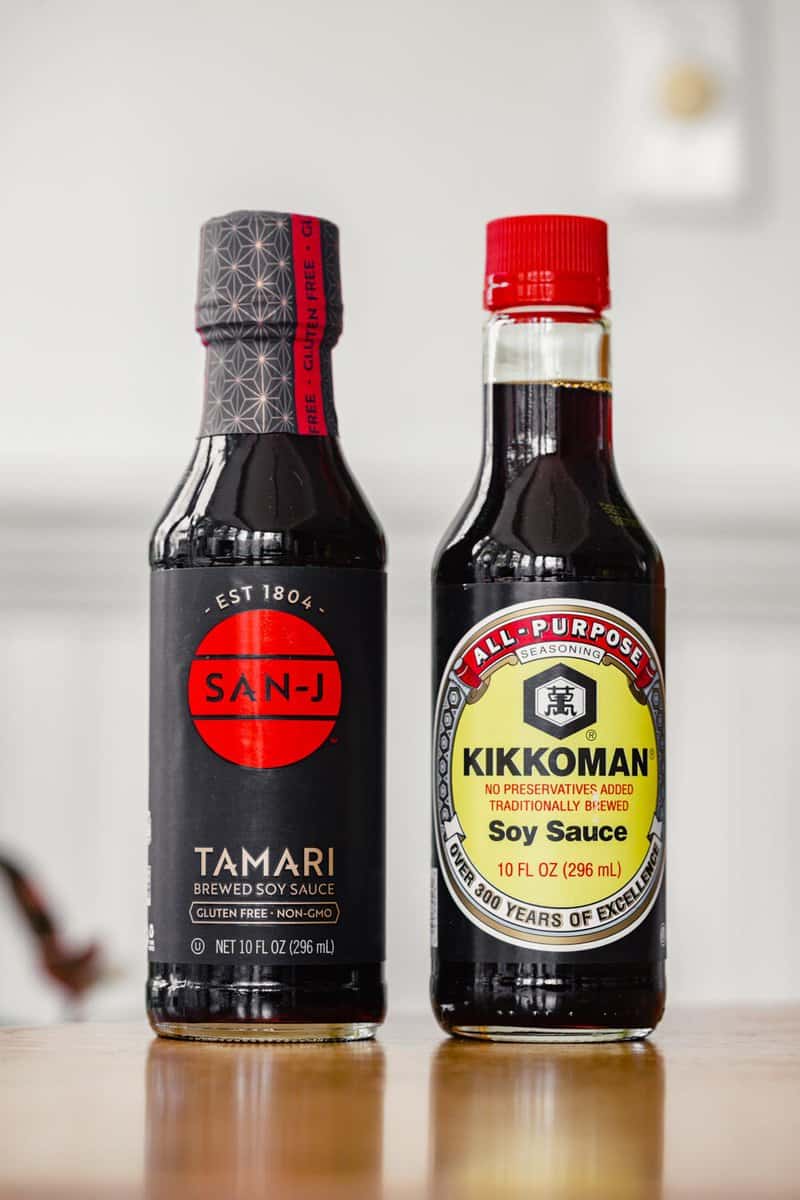 a bottle of soy sauce and a bottle of tamari set on a table