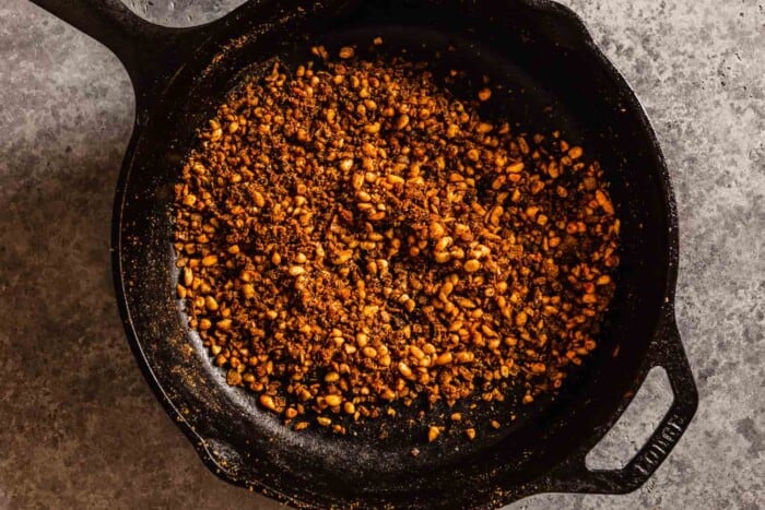 pine nuts and spices cooking in a cast-iron skillet
