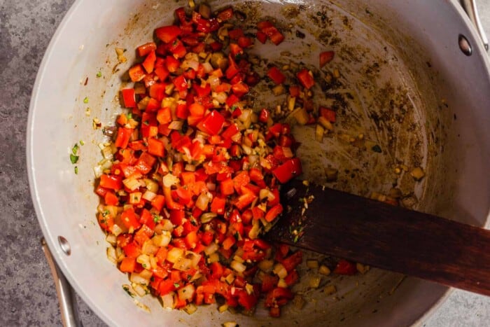 diced bell pepper and shallot cooking in a large pot
