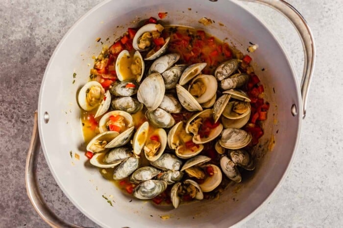 clams in a large pot with diced red bell pepper
