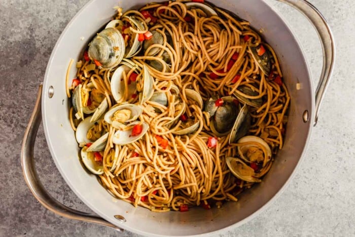 cooked clams, diced red bell pepper and spaghetti in a large pot