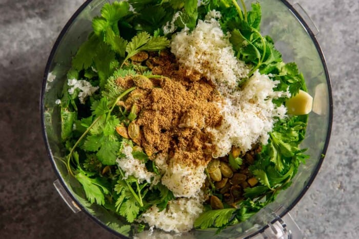 cilantro, radish greens, grated cheese, nuts, and spices in a food processor