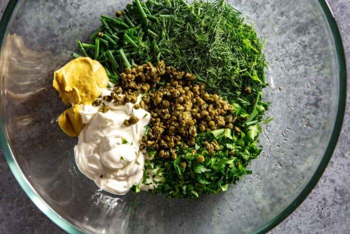 sour cream, herbs, capers and dijon in a large glass bowl