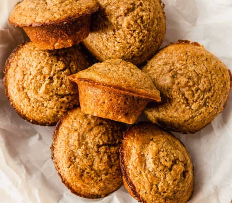 muffins piled into a bowl lined with white parchment paper