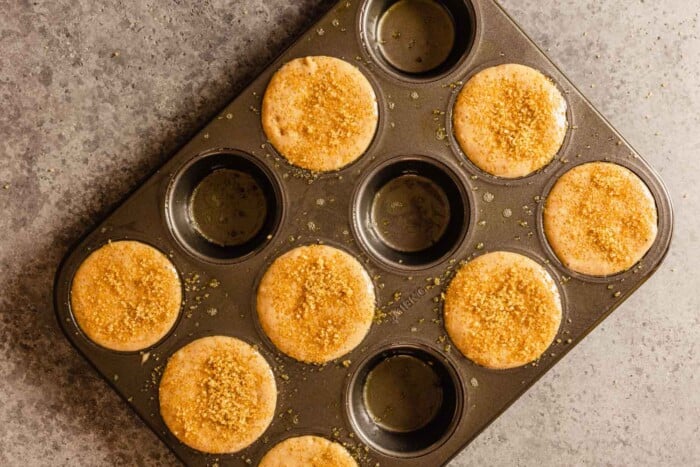 batter in muffin wells in a muffin tin and topped with sugar