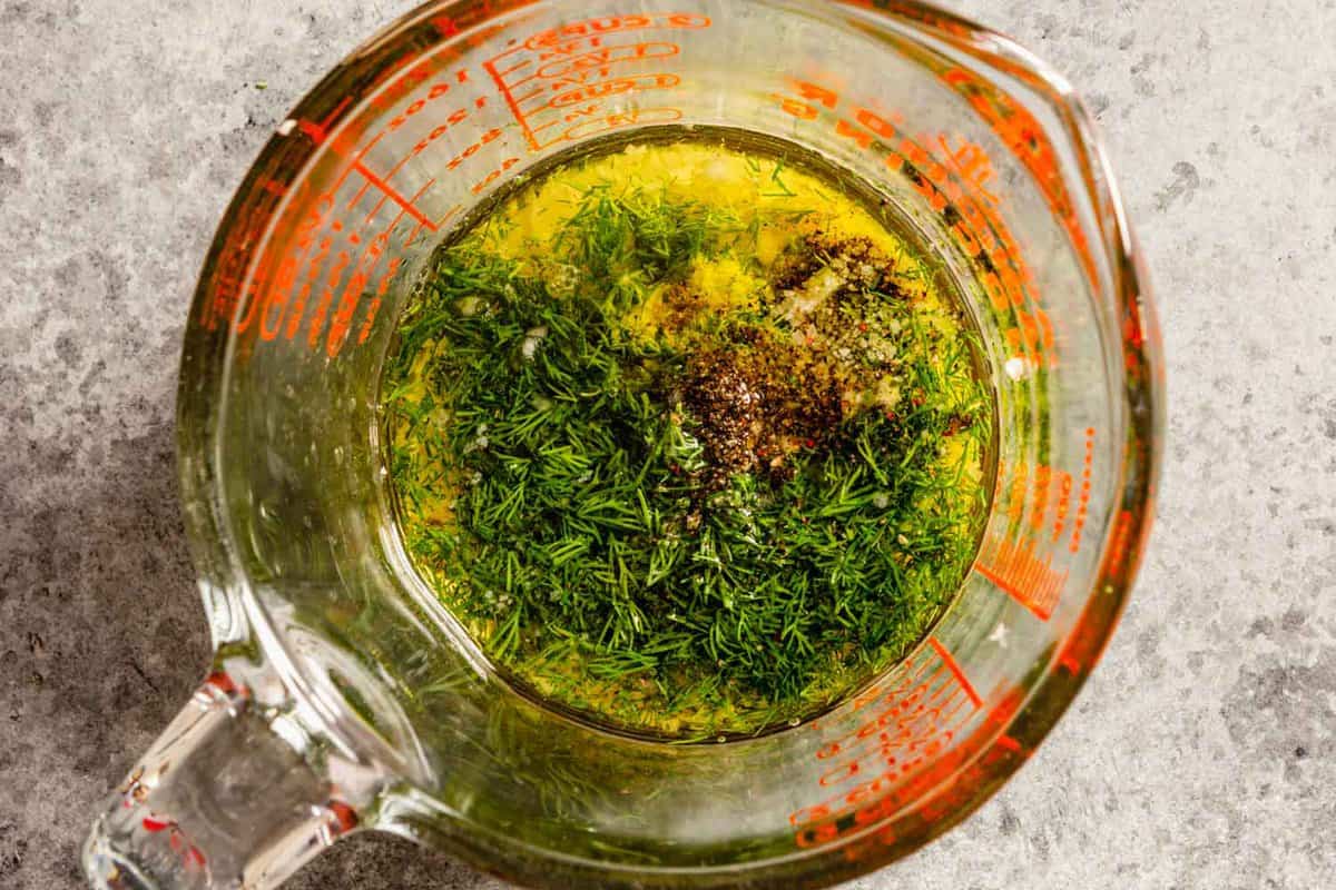 oil, fresh dill, salt, pepper and lemon juice in a glass measuring cup