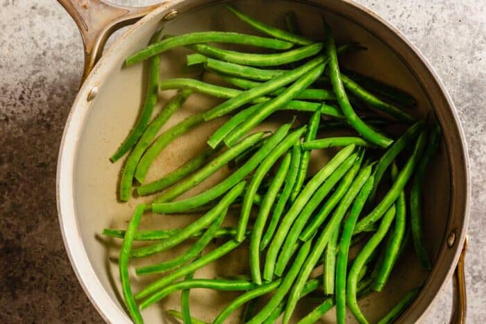 green beans in a large saute pan filled with water