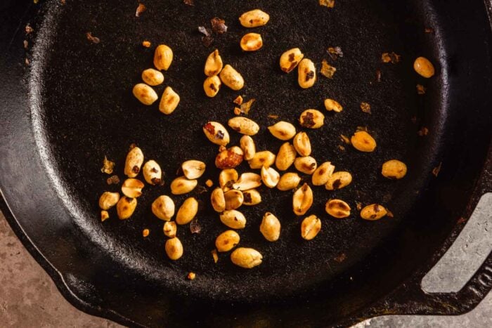 toasted peanuts in a cast-iron skillet