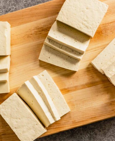 slices of tofu arranged on a wood cutting board