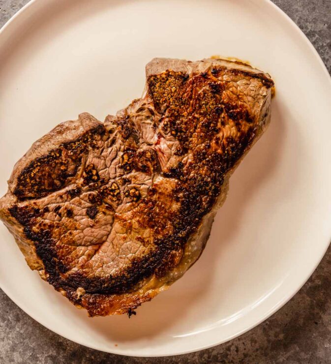 cooked beef sirloin steak on a white plate