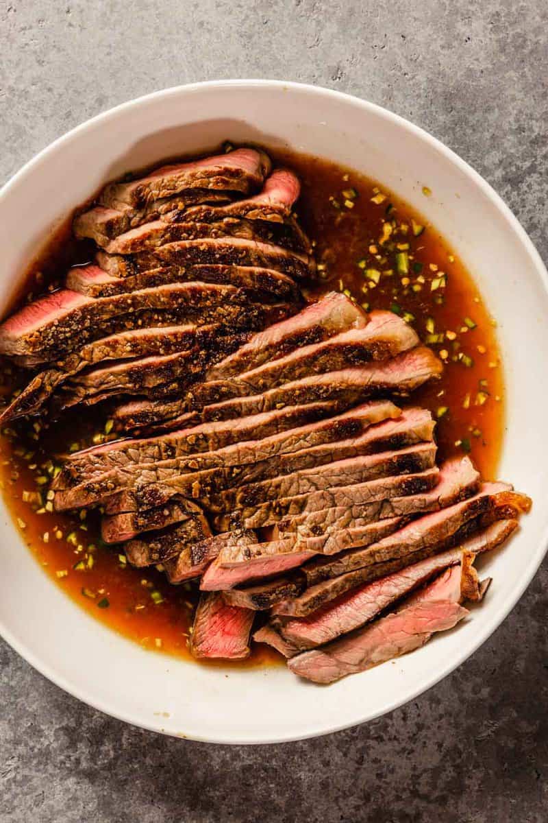 sliced cooked steak in a marinade