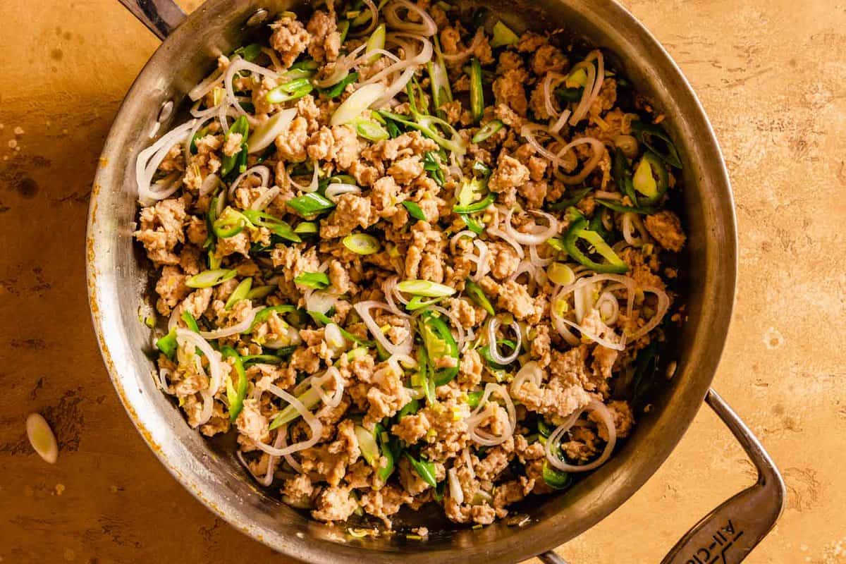 ground chicken, shallots and scallions in a skillet