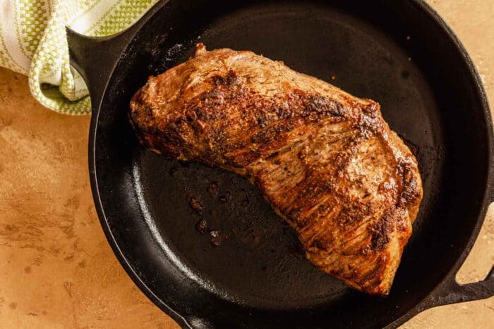 cooked tri-tip steak in a cast-iron skillet