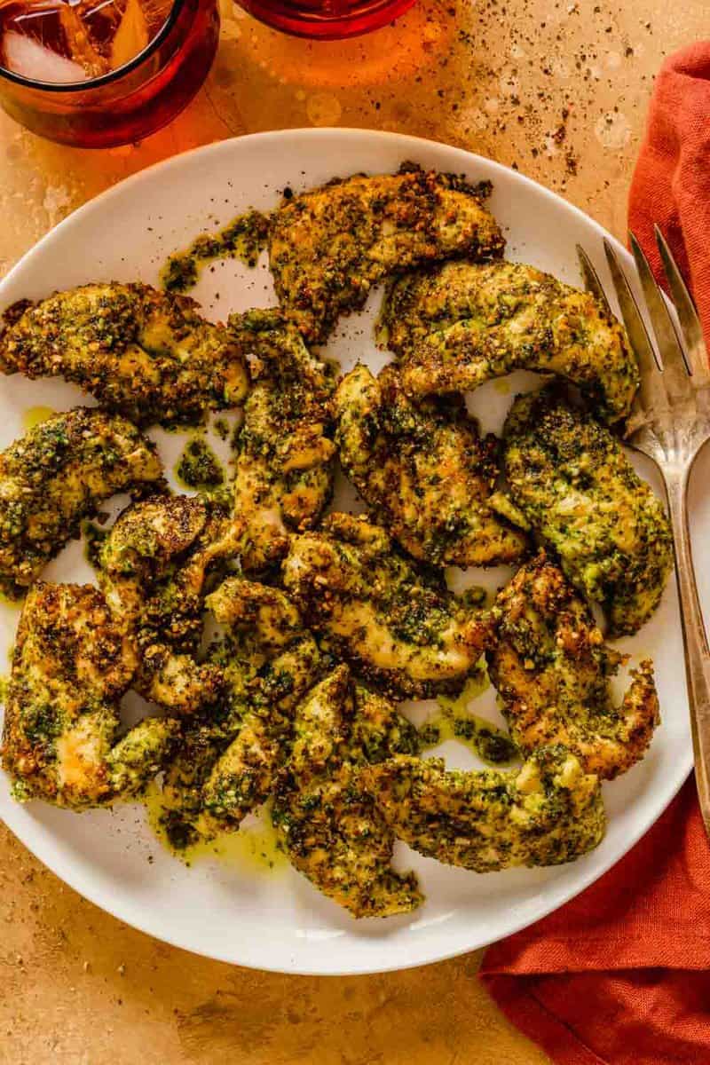 pesto-coated chicken tenders on a large white plate