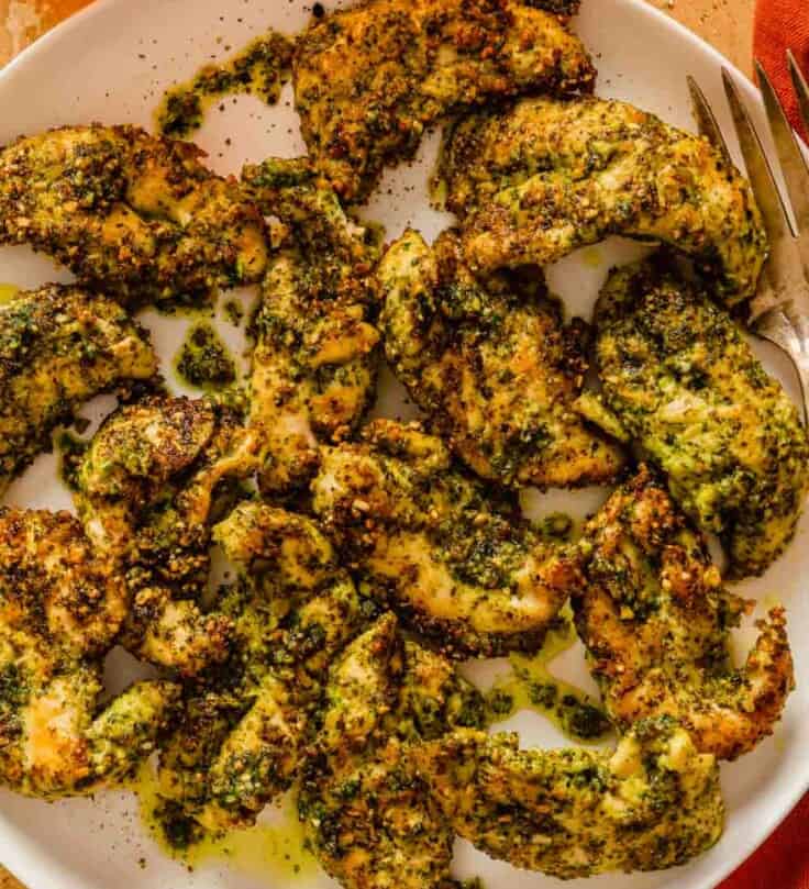 pesto-coated chicken tenders on a large white plate