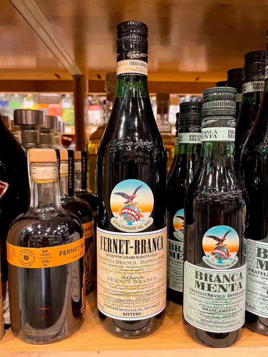 three bottles of amaro on a shelf