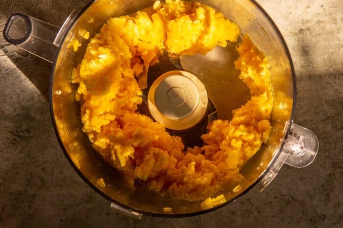 frozen mango pulsed into chunks in a food processor