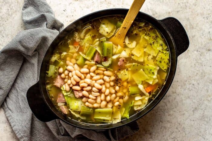broth, vegetables and white beans in a large pot.