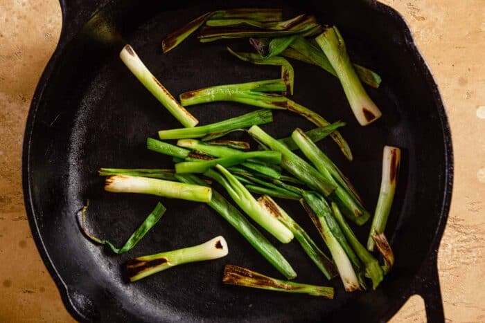 charred scallions in a cast iron skillet