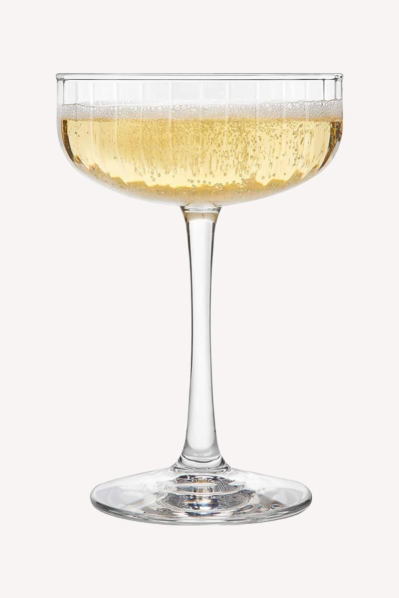 champagne coupe on a cream colored background