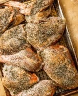 raw turkey pieces covered in salt and spices on a baking sheet