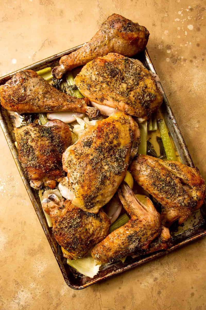 roasted turkey pieces on a sheet pan covered in vegetables