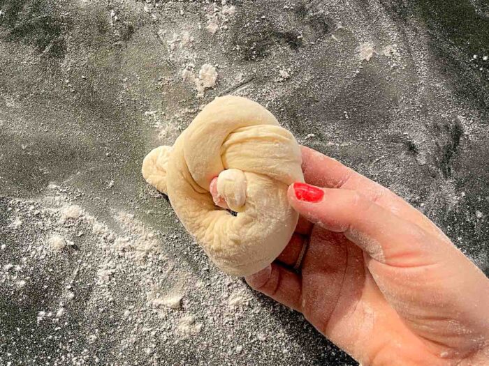 knotted roll of dough in a hand