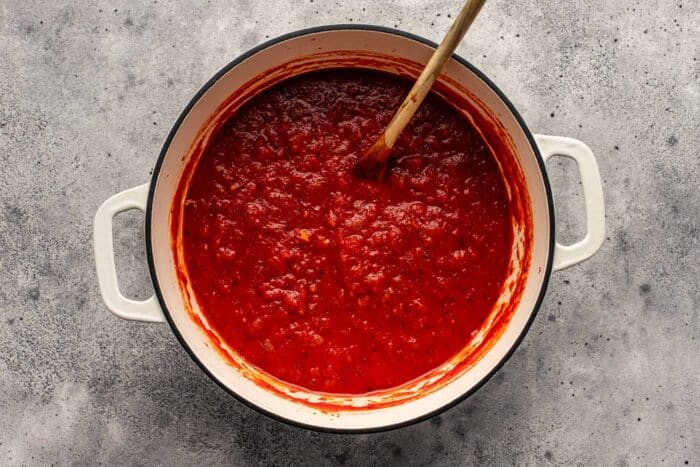 large pot of tomato sauce with a wooden spoon set in it