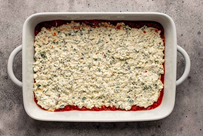 ricotta and cottage cheese mixture spread into a large white baking dish