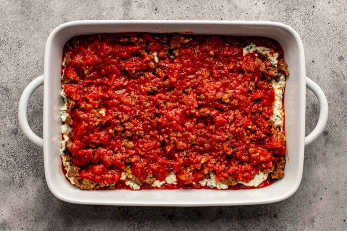tomato sauce layered in a large white baking dish