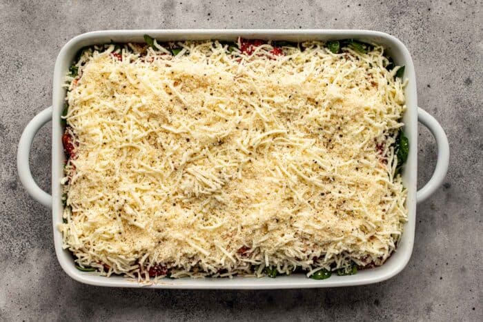 unbaked lasagna in a large white baking dish