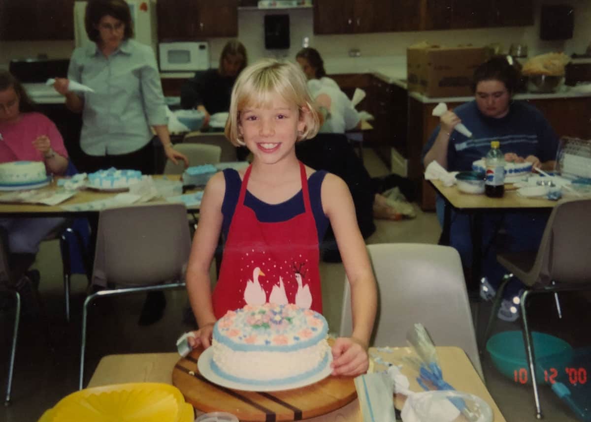 young girl holding a decorated cake
