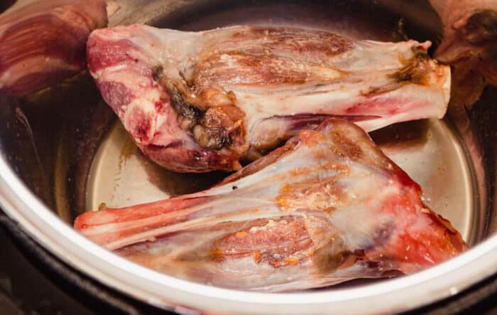 raw lamb shanks browning in an instant pot