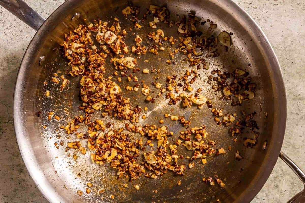 minced shallot garlic and spices cooking in a sauté pan