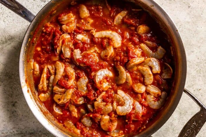 raw shrimp cooking in a spicy tomato sauce in a sauté pan
