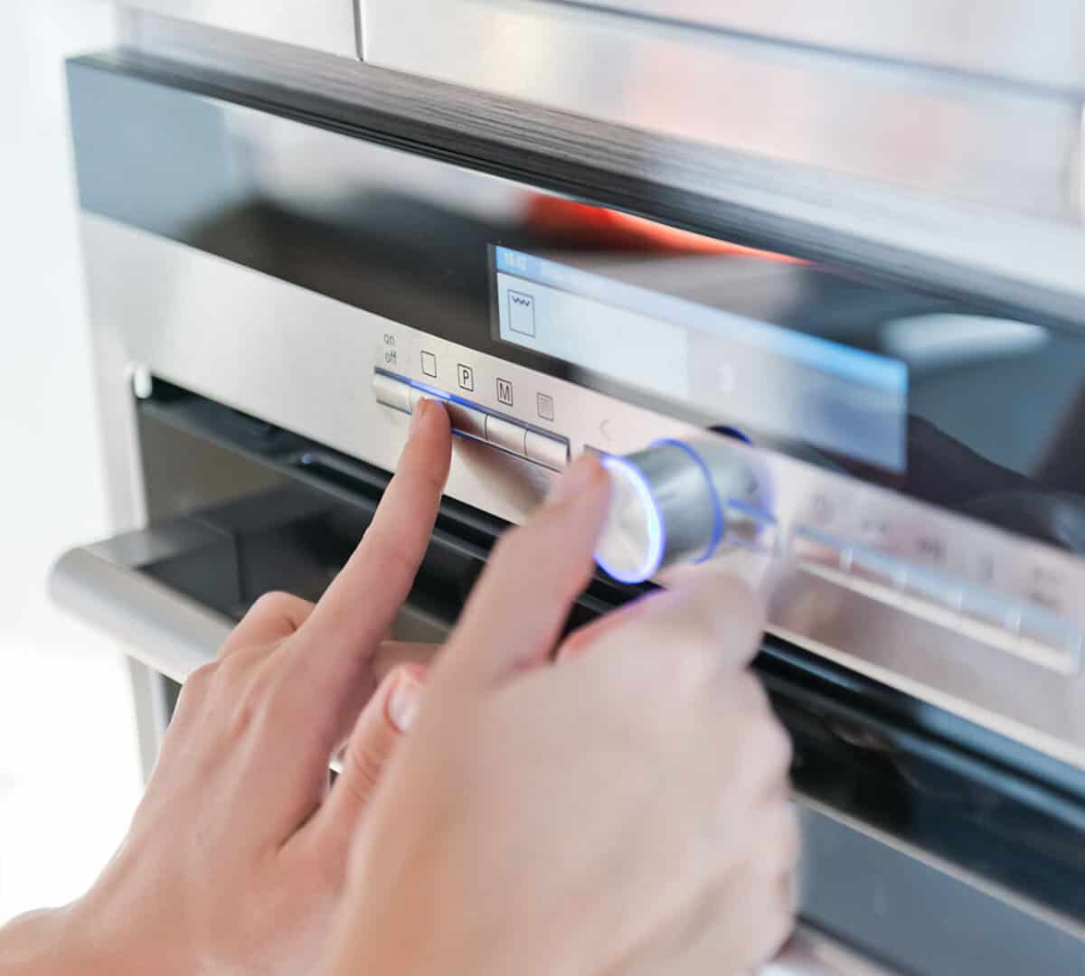 hand moving the knob on an oven