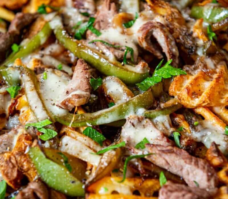 fries topped with steak, cheese and sliced bell peppers.