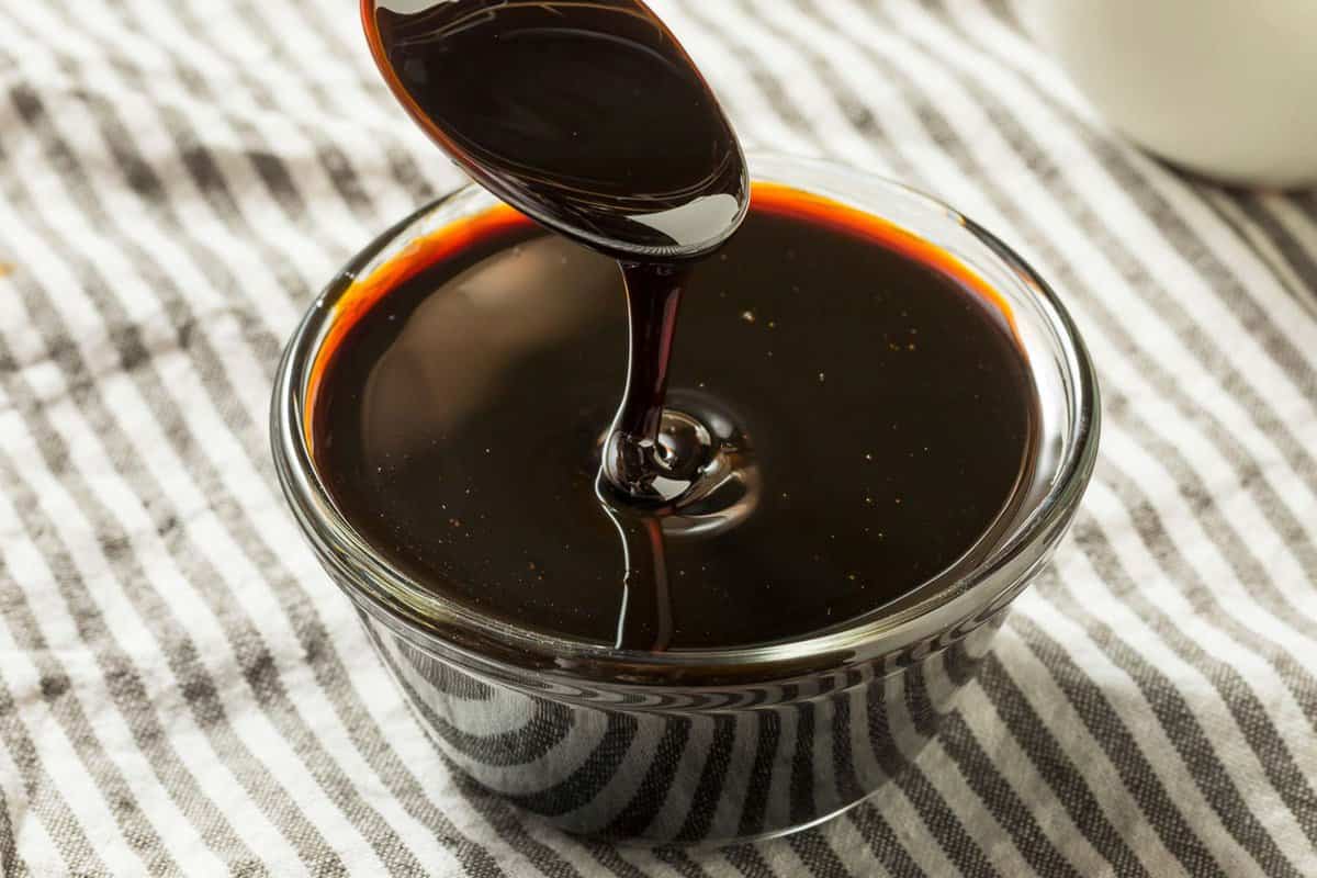 molasses drizzling into a glass jar