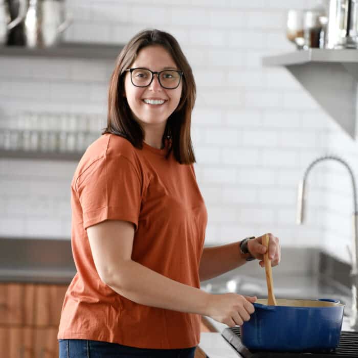 brunette woman in an orange t-shirt at a stove