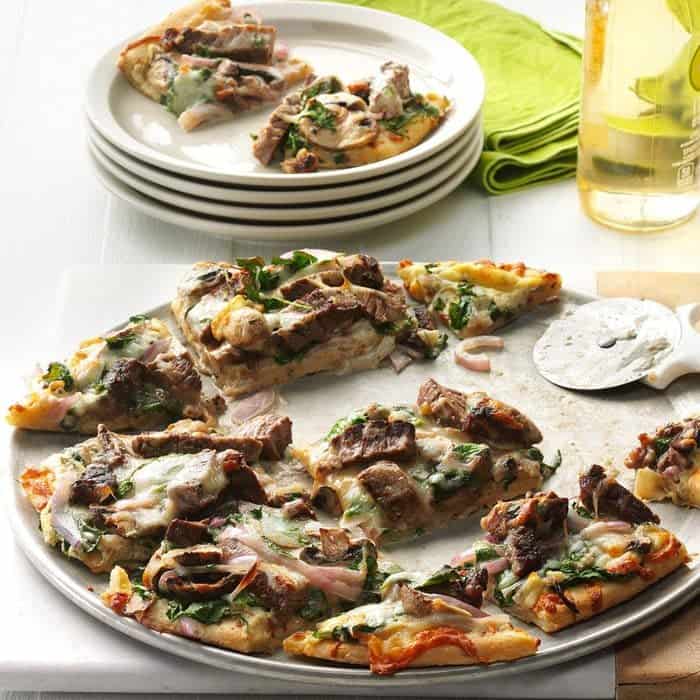 pieces of steak pizza set on a white plate